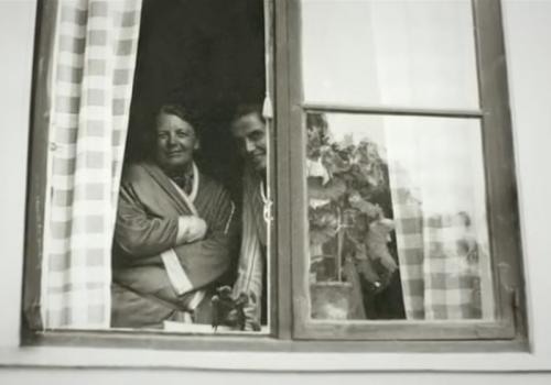 Ada Nilsson och Honorine Hermelin tittar ut genom ett fönster på Elisabeth Tamms gård Fogelstad